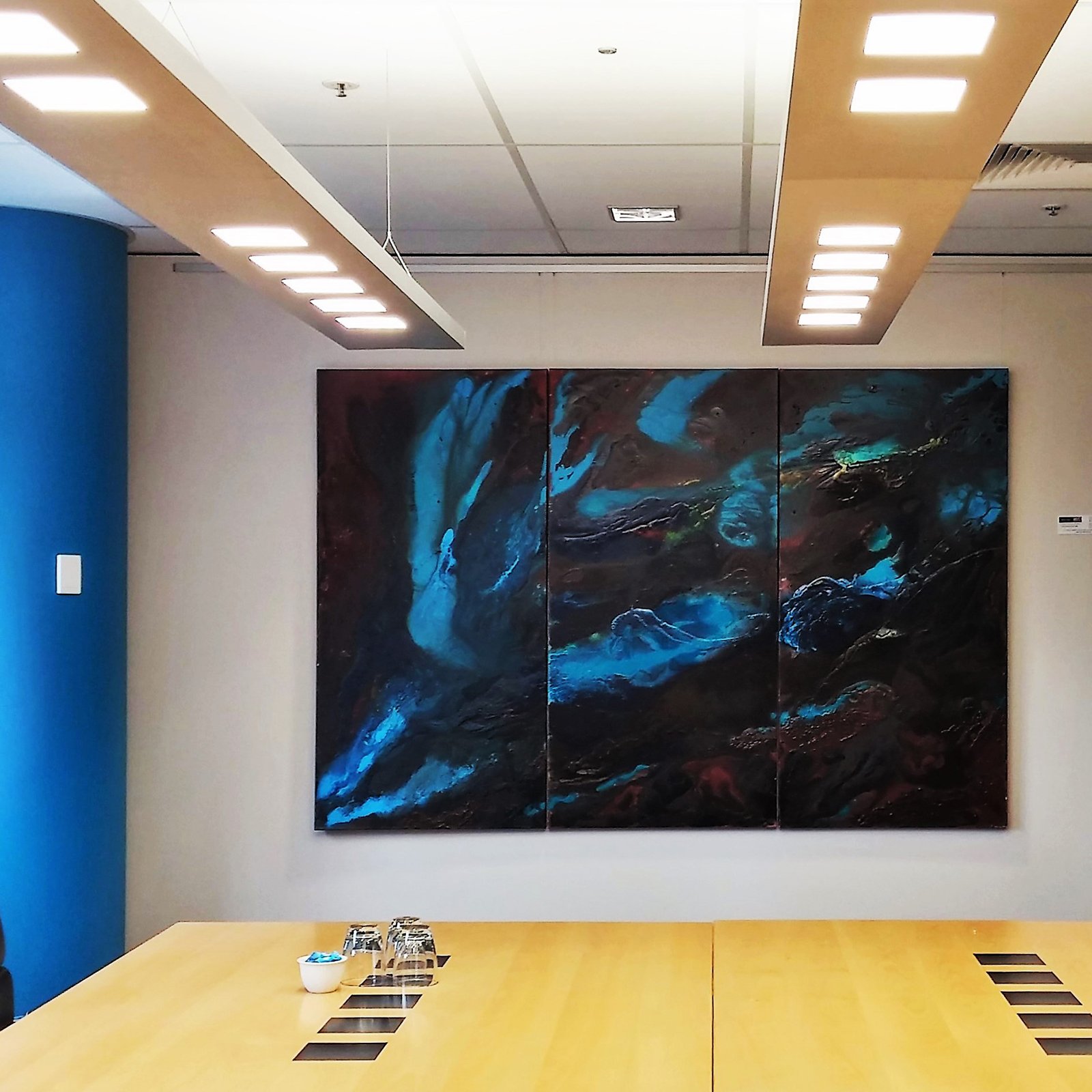 Large blue abstract triptych hung on perlon wires from brushed aluminium ArtiTeq Click Rail picture rail in boardroom