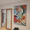 Colourful abstract canvas hung on clear perlon wires from an ArtiTeq Click Rail picture rail in a hallway