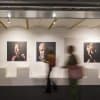 Gallery portraits hung on ArtiTeq Click Rail Pro picture rail with clear perlon wires in a modern exhibition space
