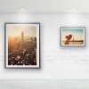 Two framed city prints on white brick wall hung from hidden ArtiTeq Shadowline Masonry picture rail with slim shadow line