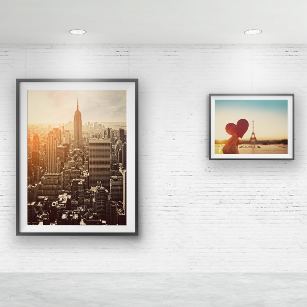 Two framed city prints on white brick wall hung from hidden ArtiTeq Shadowline Masonry picture rail with slim shadow line