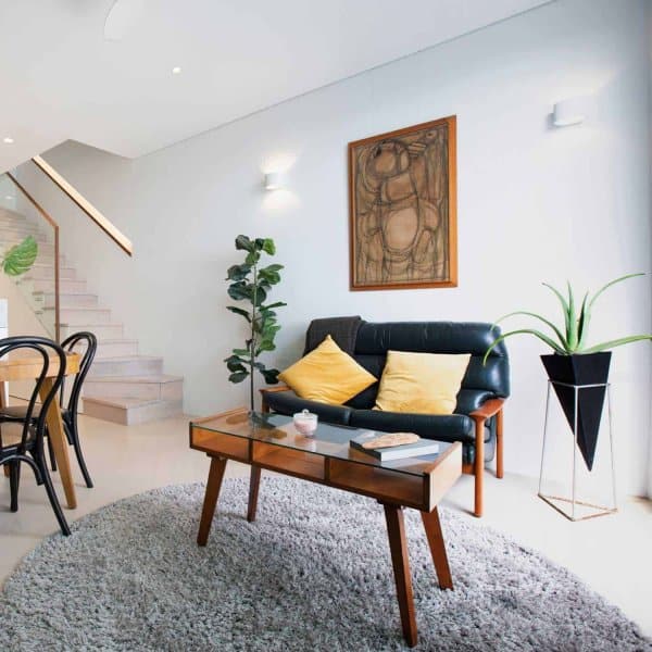 Framed abstract above sofa hung on clear wires from hidden ArtiTeq Shadowline Masonry picture rail in modern living room
