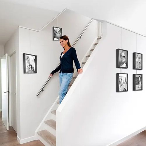 photos hanging in stairway with sloped walls