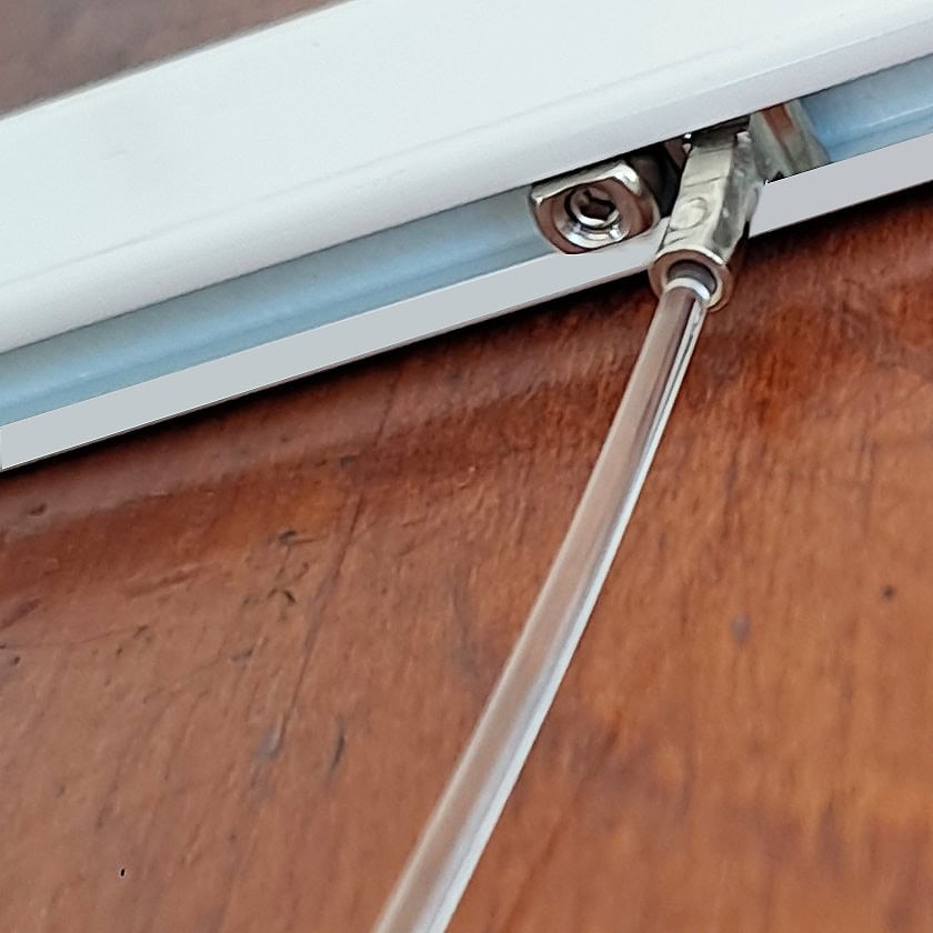 Sloped rail stopper holding wire position Sloped rail stopper positioned under a hanging wire in a picture rail to prevent sliding on an angled wall.