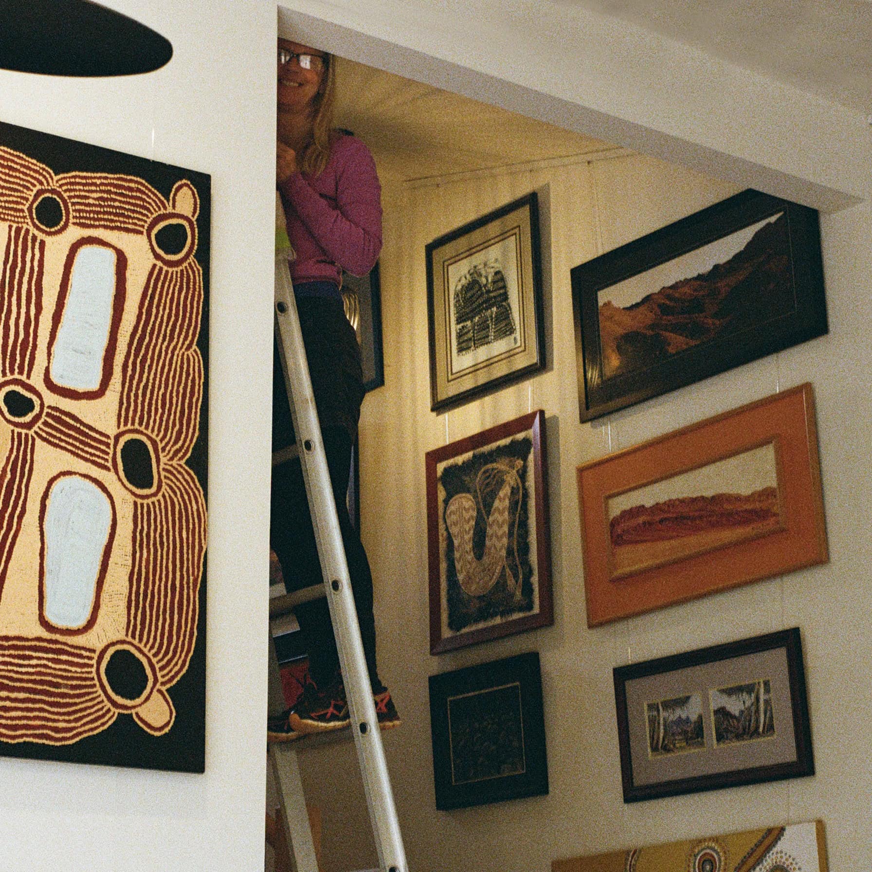 Stairwell picture hanging on a sloped wall Stairwell gallery wall with multiple artworks hung on picture rails along a raked ceiling line.