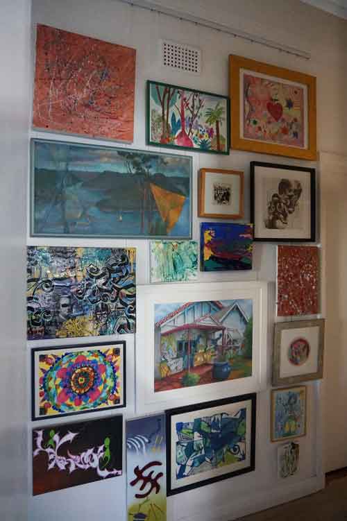 Colorful framed artworks displayed on a wall using Hang Logic Click Rail picture hanging system.