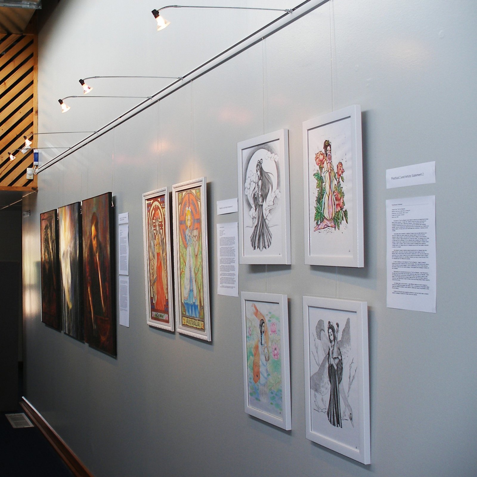 Long school corridor display with 70 cm light arms washing framed illustrations