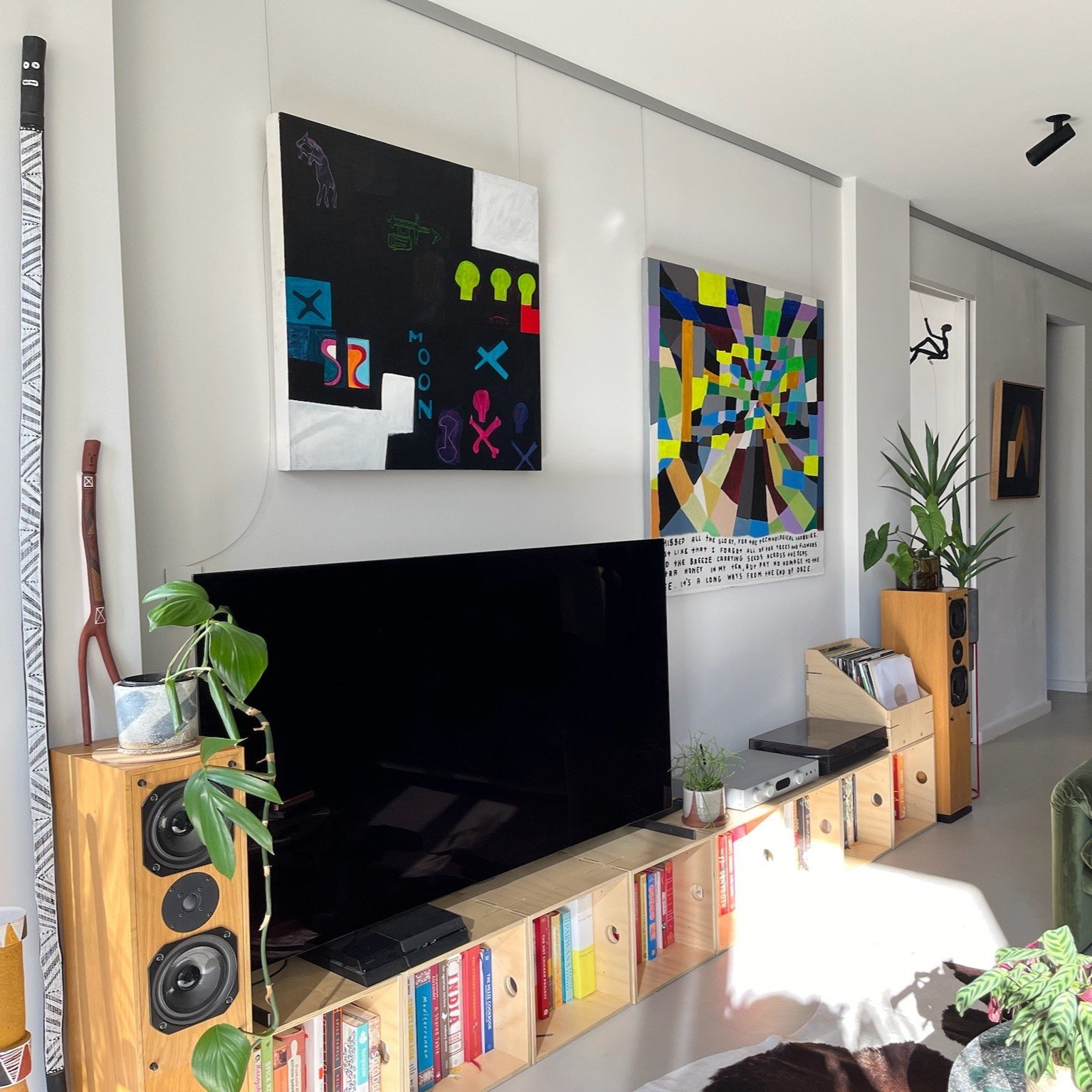 Click Rail Pro Lounge Room - Hang Logic Two colourful canvases above TV hung on clear wires from brushed aluminium Click Rail Pro picture rail in modern lounge room