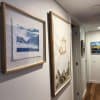 Framed artworks in hallway hung on wires from hidden ArtiTeq Shadowline Drywall picture rail