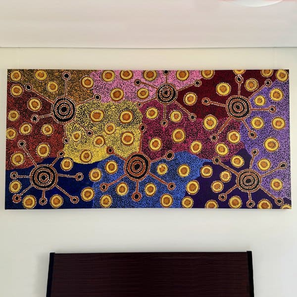 Colourful dot canvas above bed hung on wires from hidden ArtiTeq Shadowline Drywall picture rail
