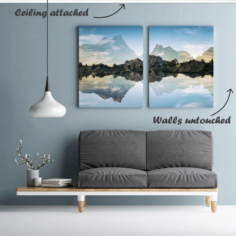 ArtiTeq Up Rail Ceiling-Fixed Picture Rail Two landscape canvases hanging on thin wires from an ArtiTeq Up Rail fitted at the wall-ceiling junction above a grey sofa.