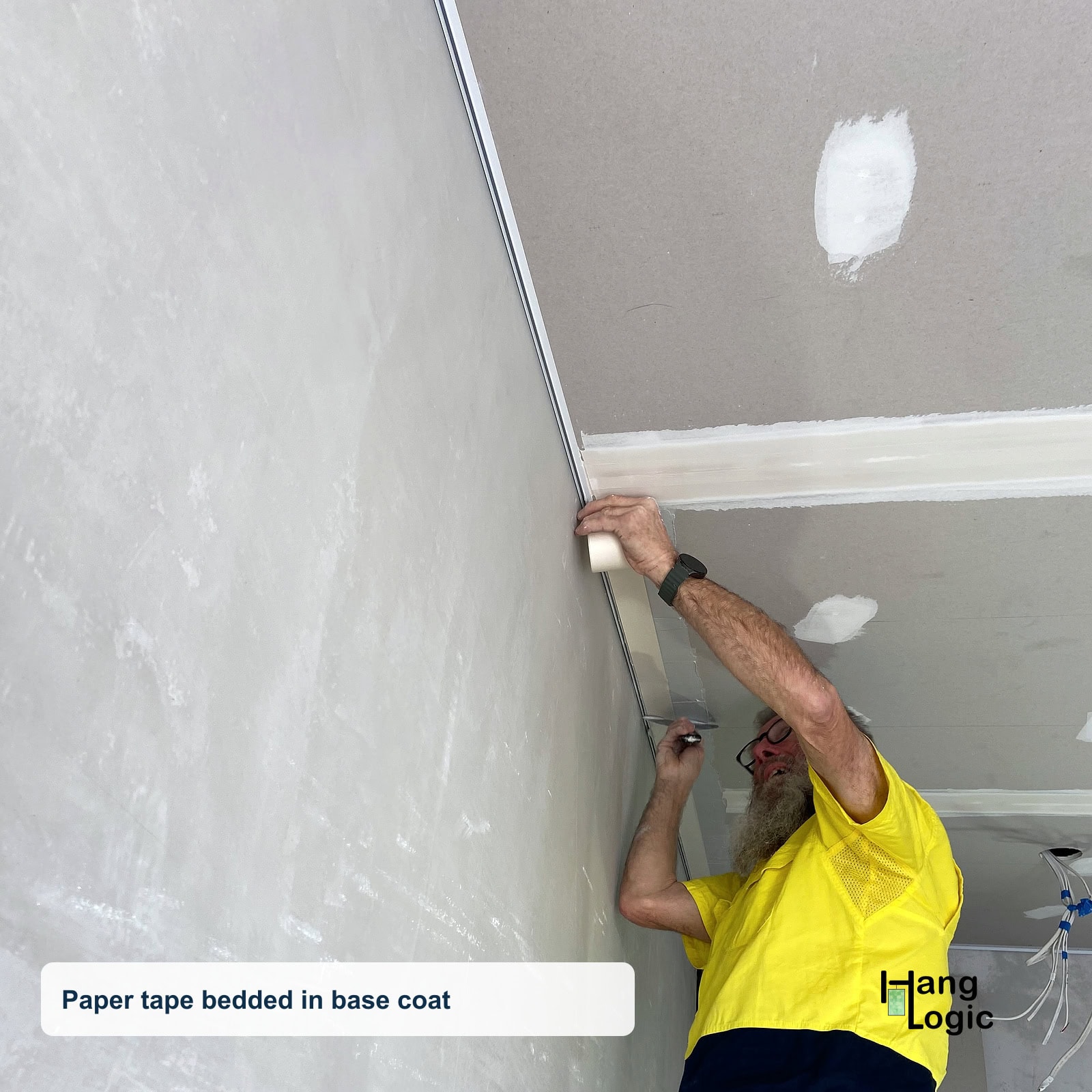 Plasterer applying paper tape along the Shadowline Masonry junction